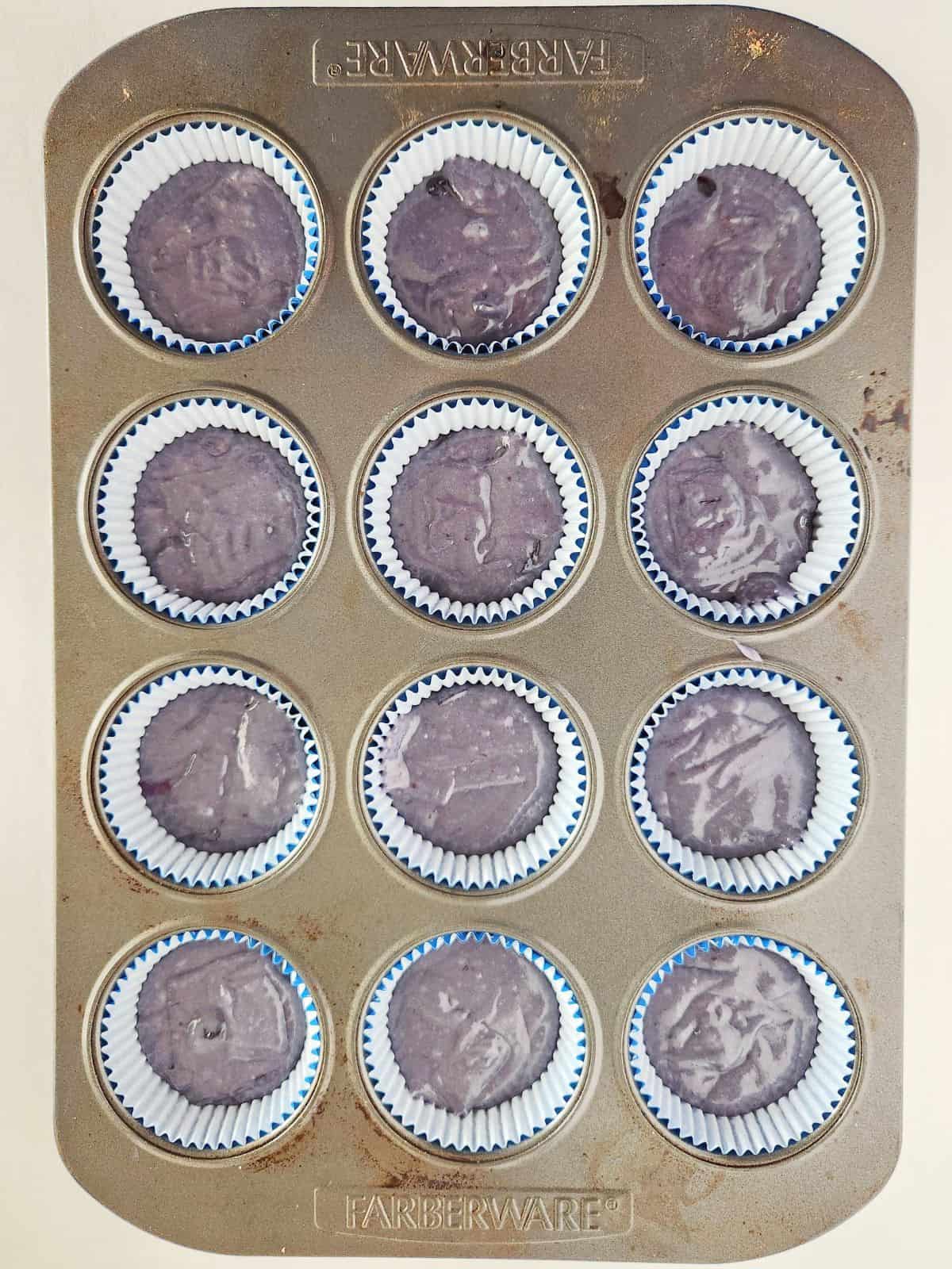 blueberry cupcake batter in muffin tin.