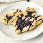 Blueberry Puff Pastry Danish on White Plate with powdered sugar.