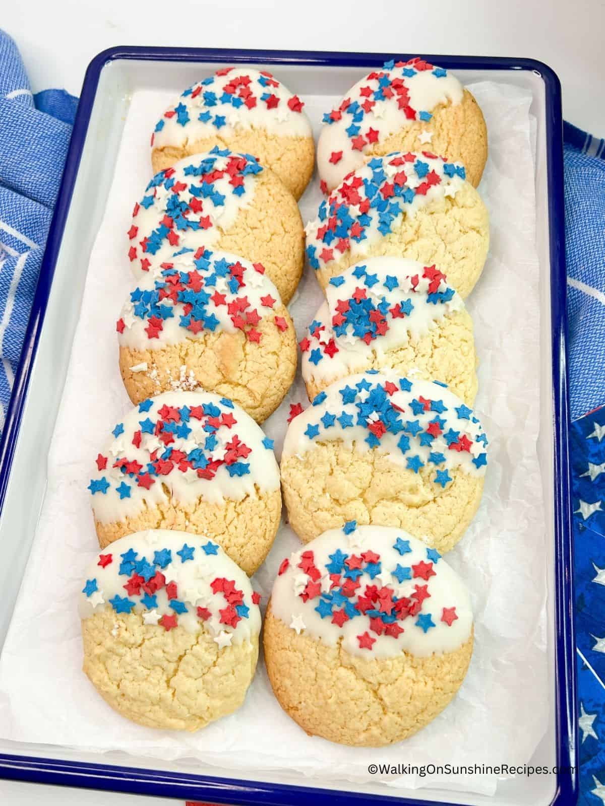 4th of July Cake Mix Cookies dipped in white chocolate and sprinkled with patriotic sprinkles.