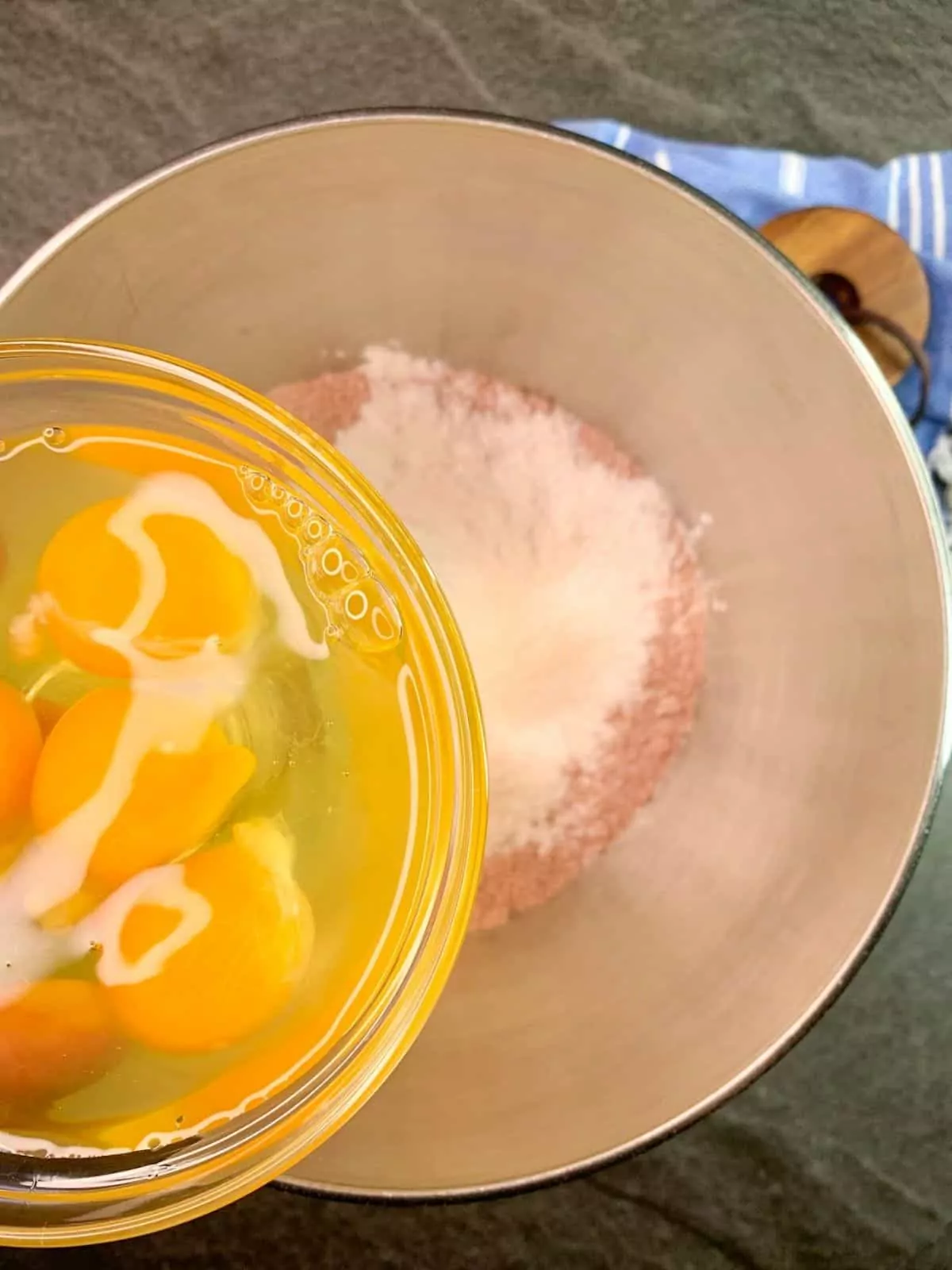 adding eggs to cake mix in mixing bowl.