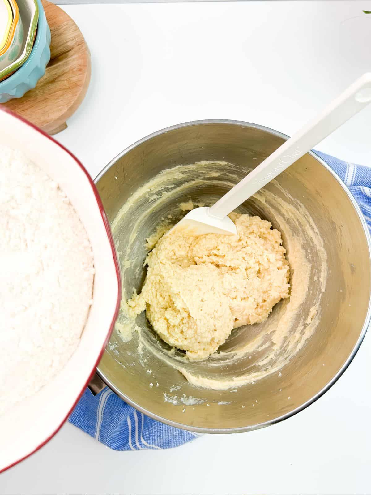 bowl of flour over butter, sugar, egg mixture in bowl.