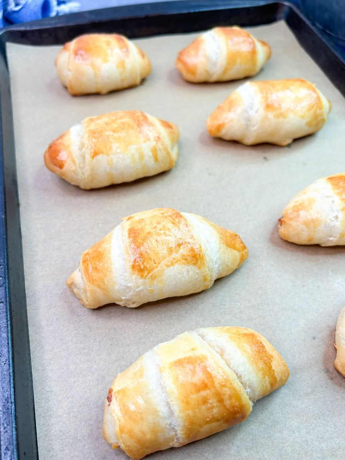 baked crescent rolls on parchment paper lined baking sheet.