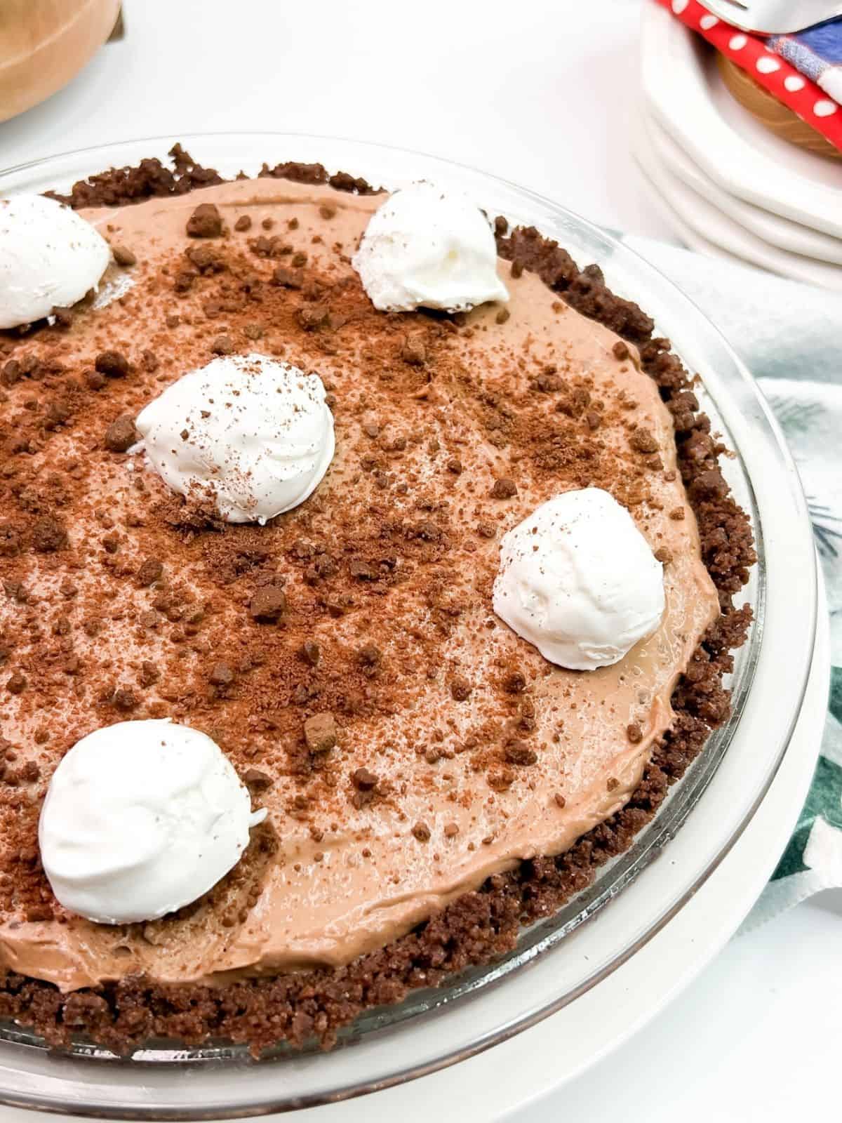 Chocolate pie with whipped cream dollops on top.