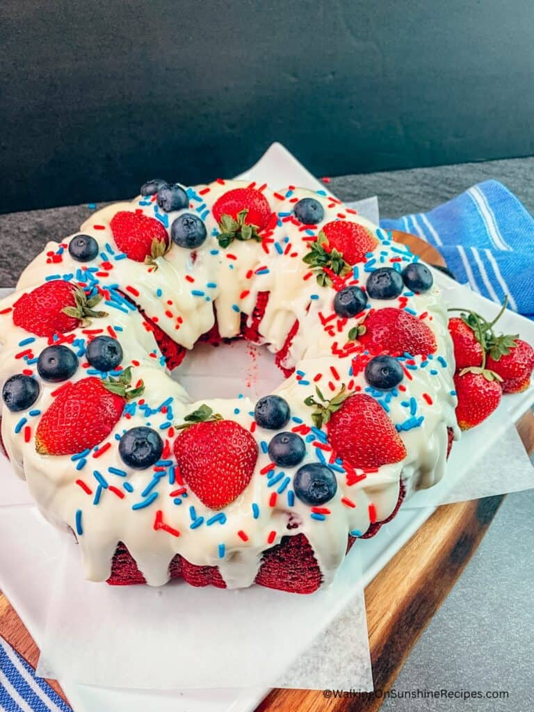 Red velvet cake decorated with blueberries, strawberries and homemade cream cheese frosting.