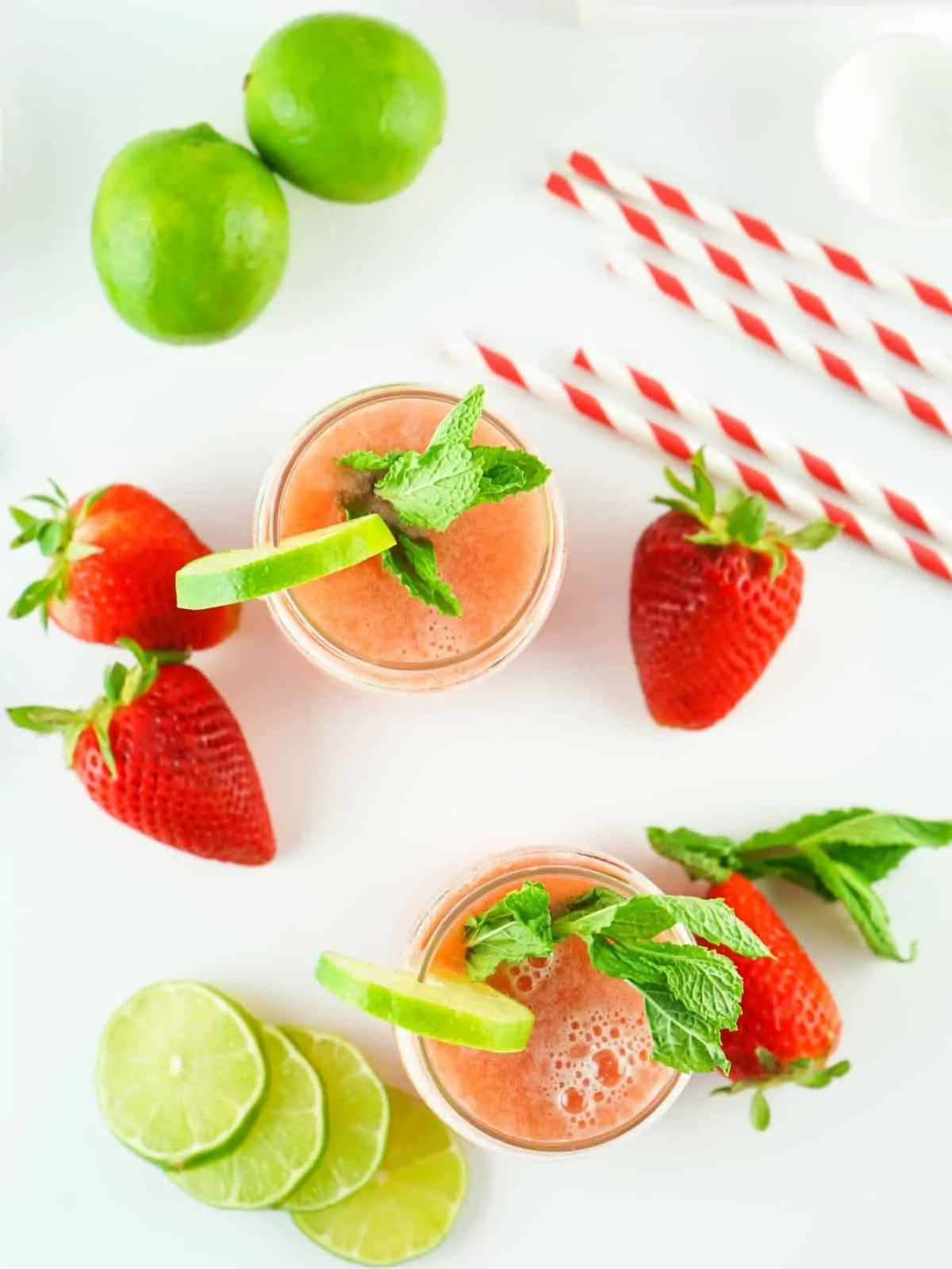 overhead view of strawberry water in glasses with lime slices and mint.