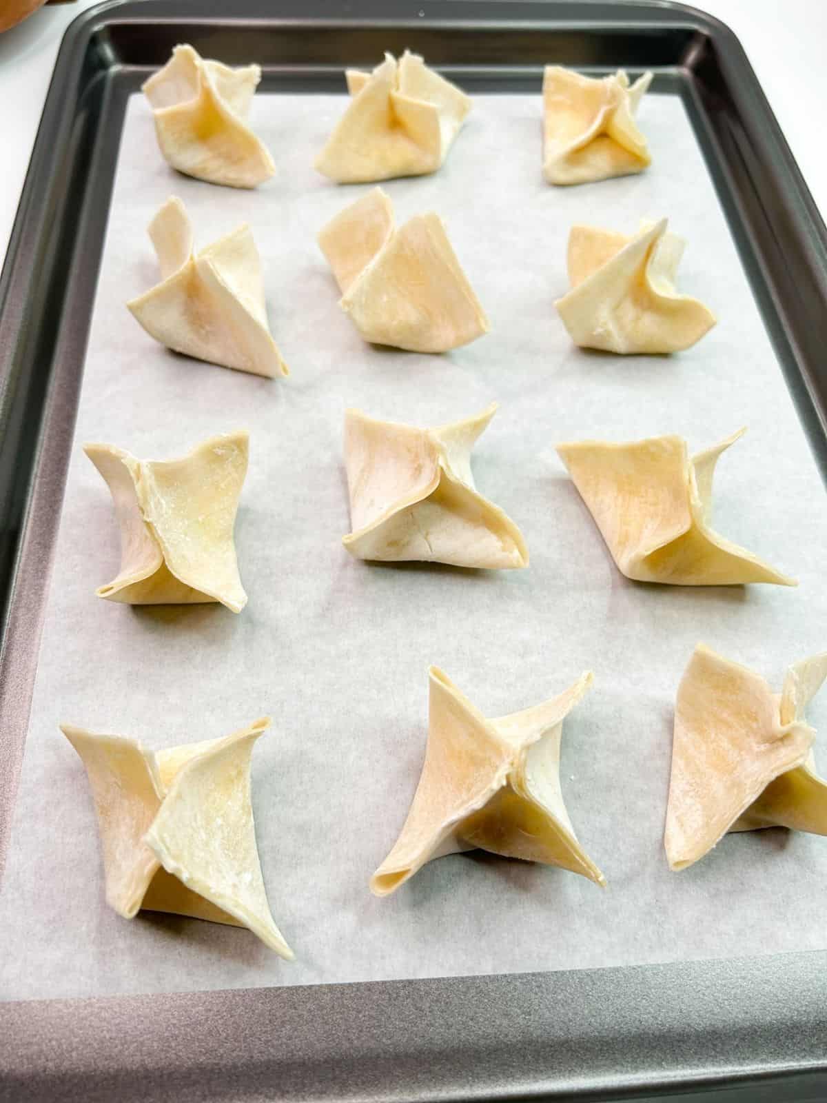 won tons formed on baking trays with parchment paper.
