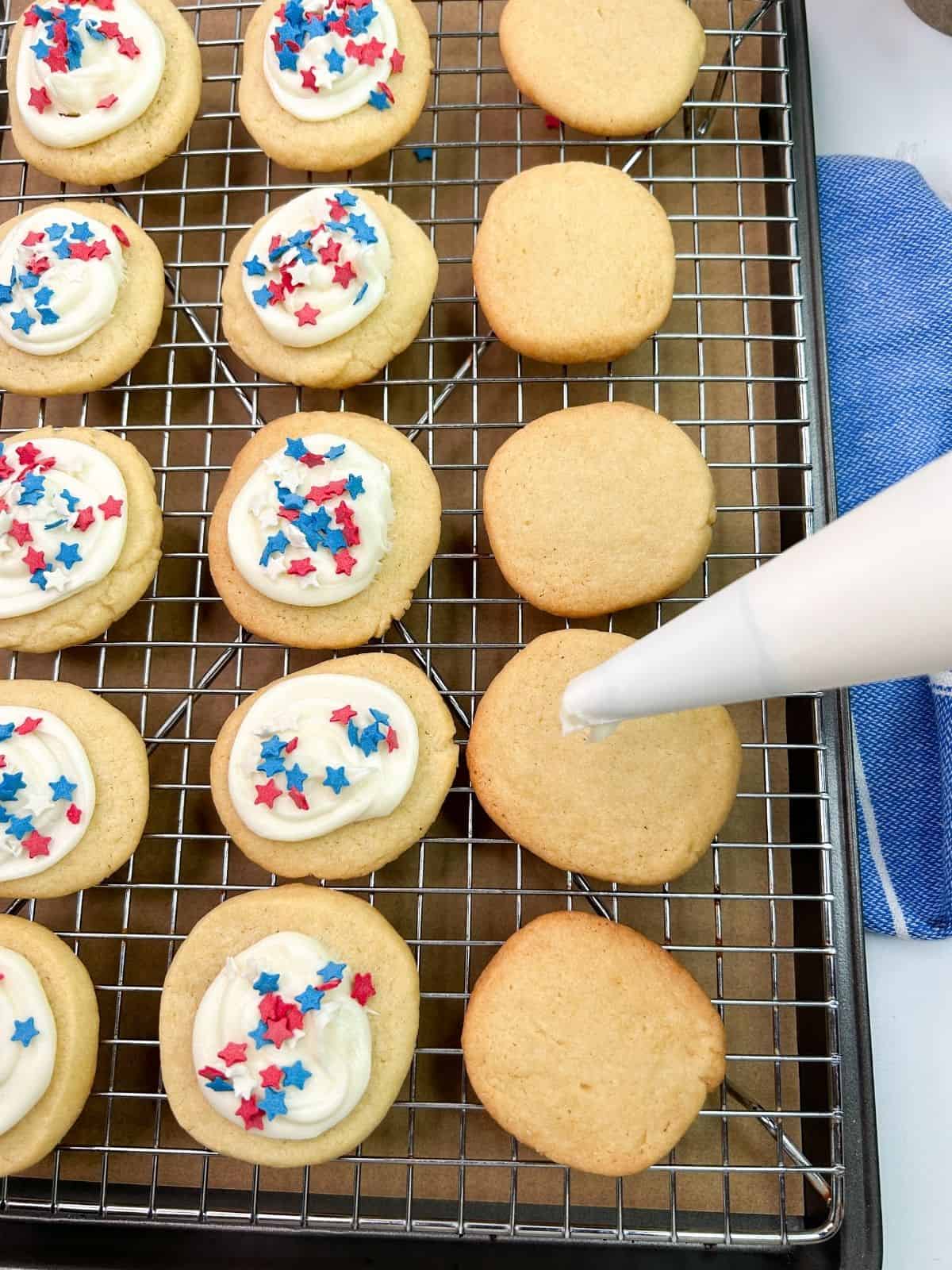 decorated cookies on baking rack with pastry bag.