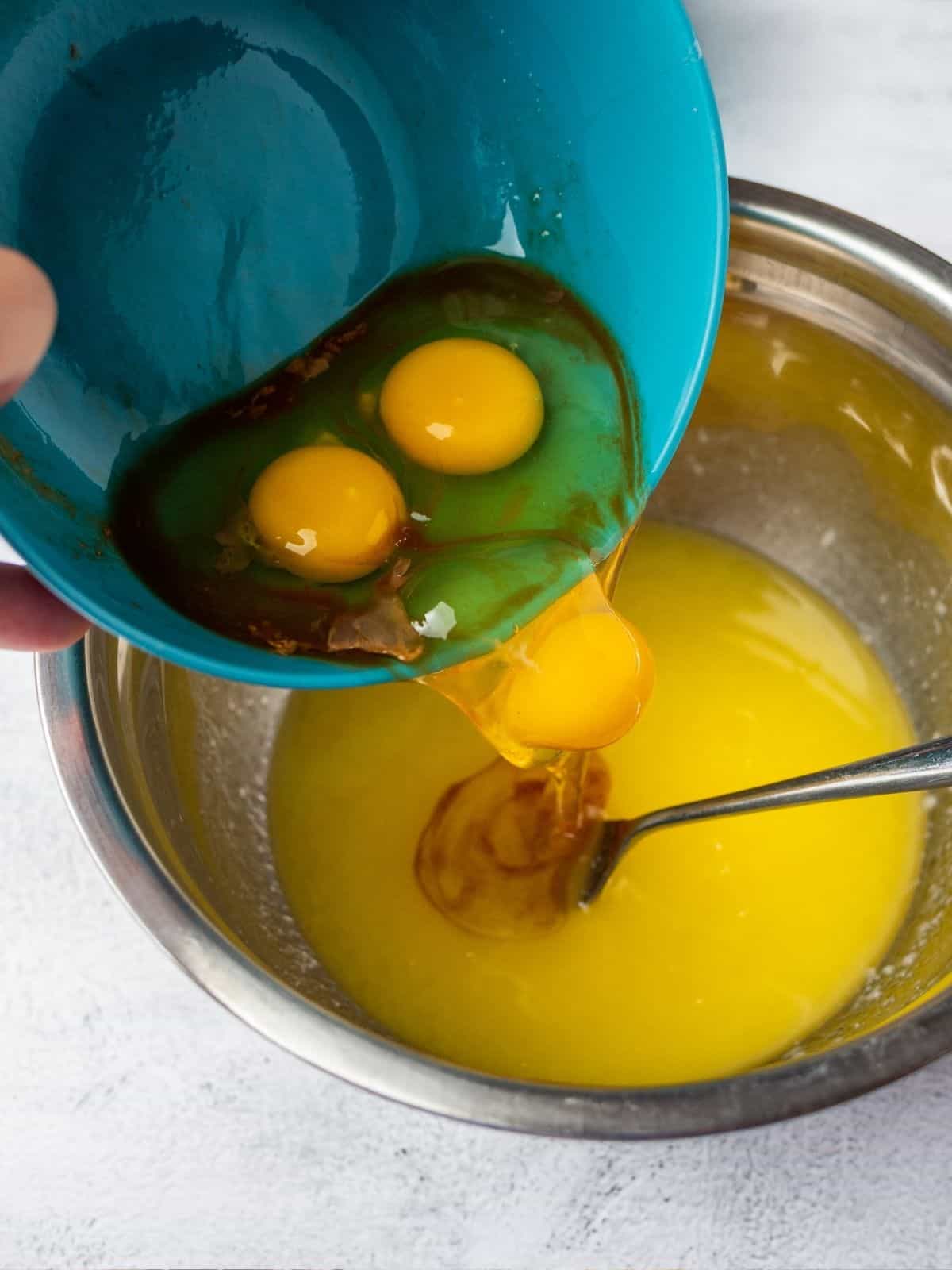 Add eggs to melted butter in bowl.