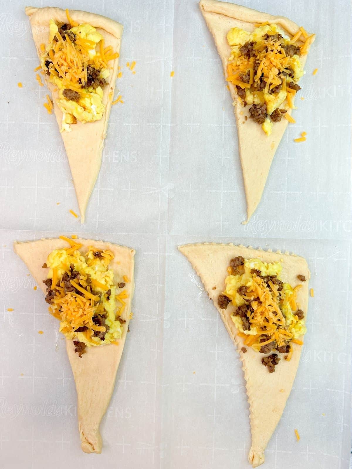 crescent roll triangles with eggs, sausage and cheddare cheese.