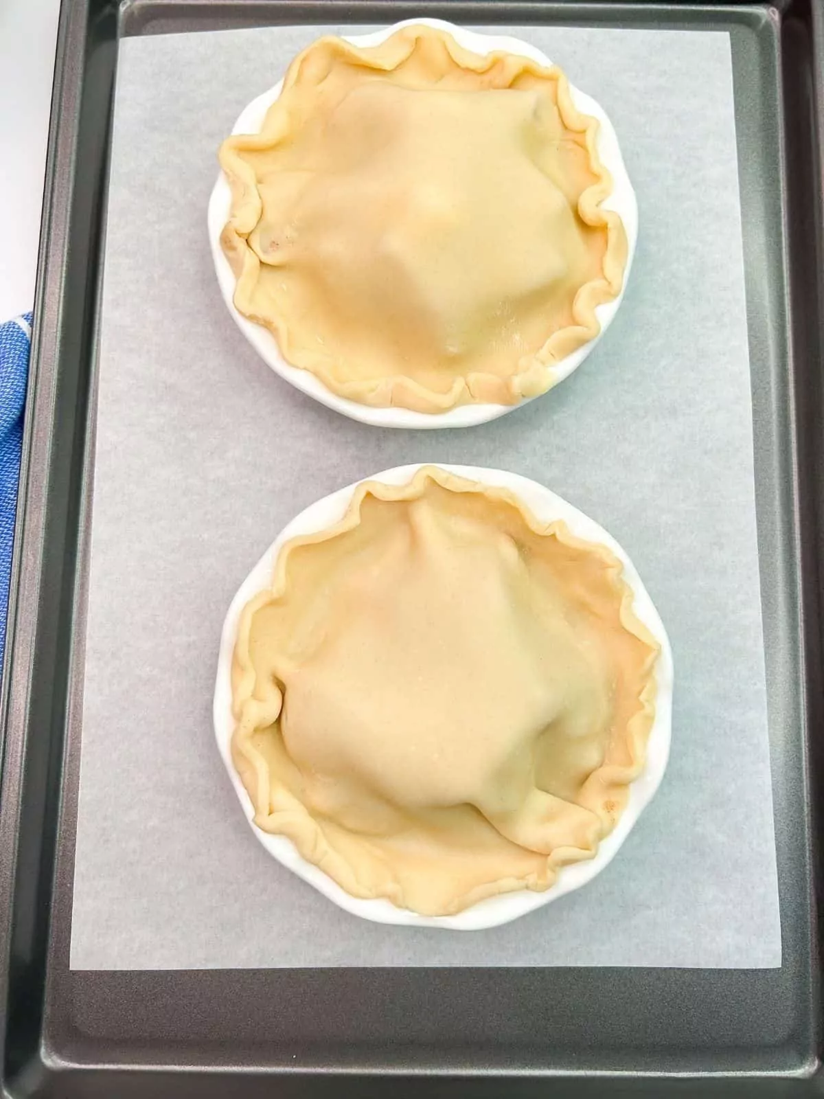 unbaked apple pies on baking tray.