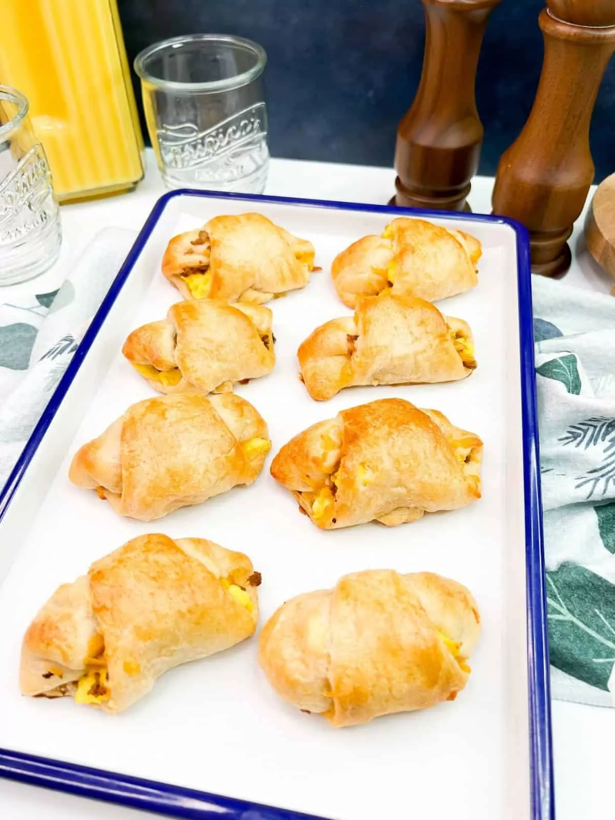 baked crescent rolls on white and blue tray.