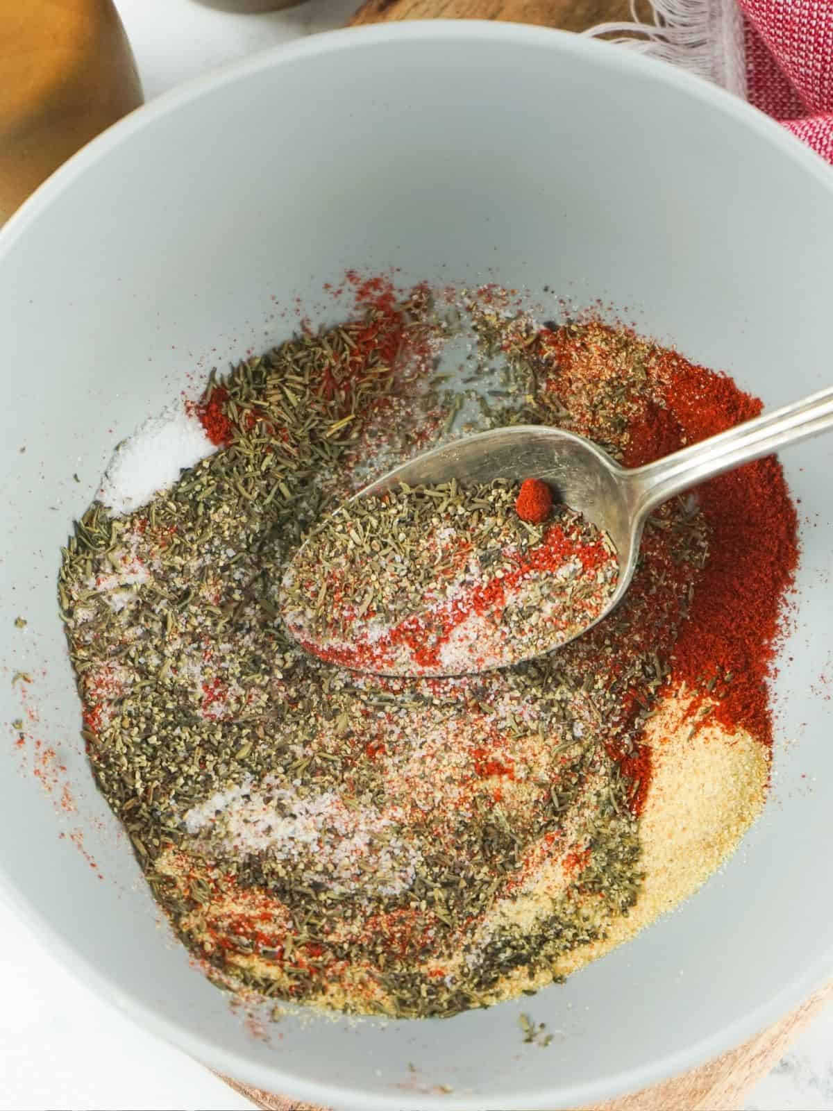 steak seasoning mix combined together in white bowl with spoon.