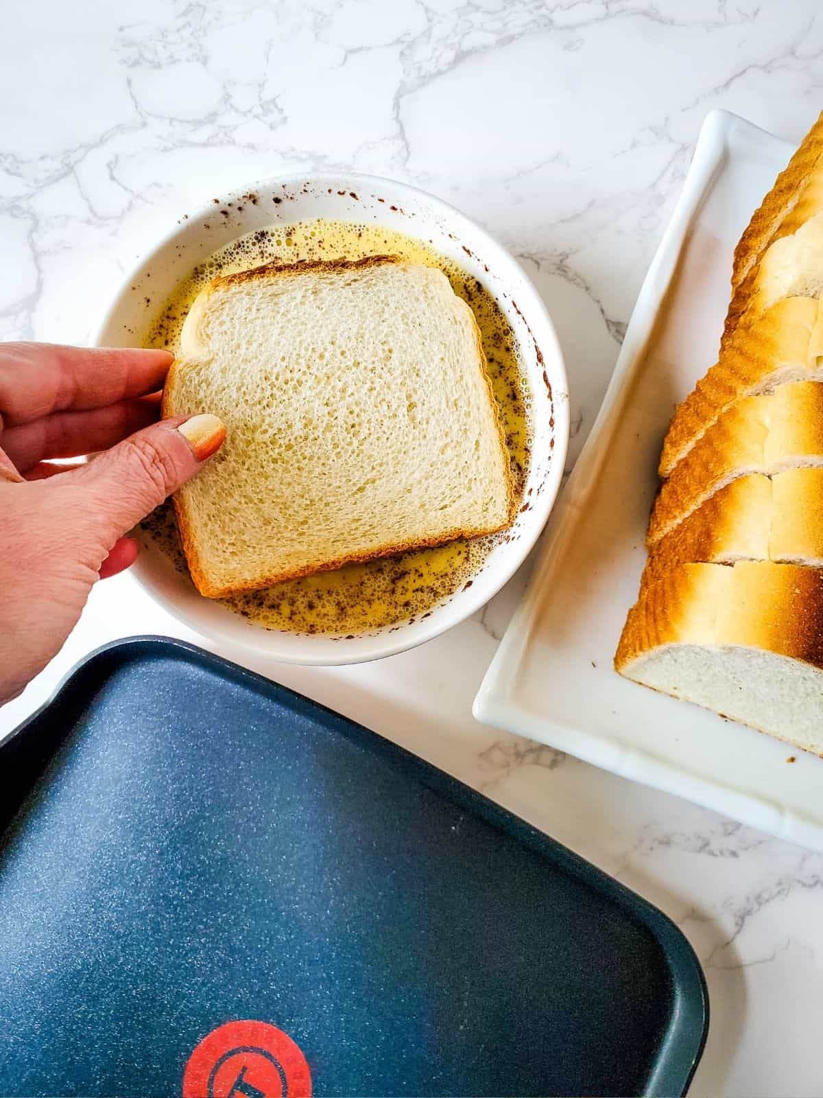 Dipping bread in egg mixture.