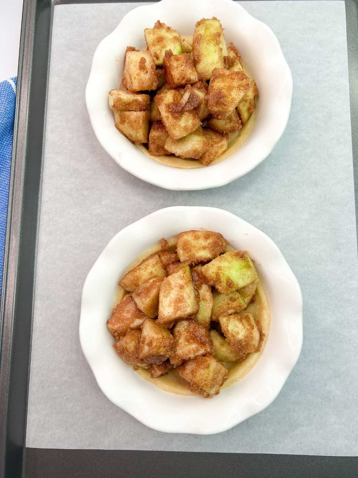 2 small pie plates on baking tray with apples.