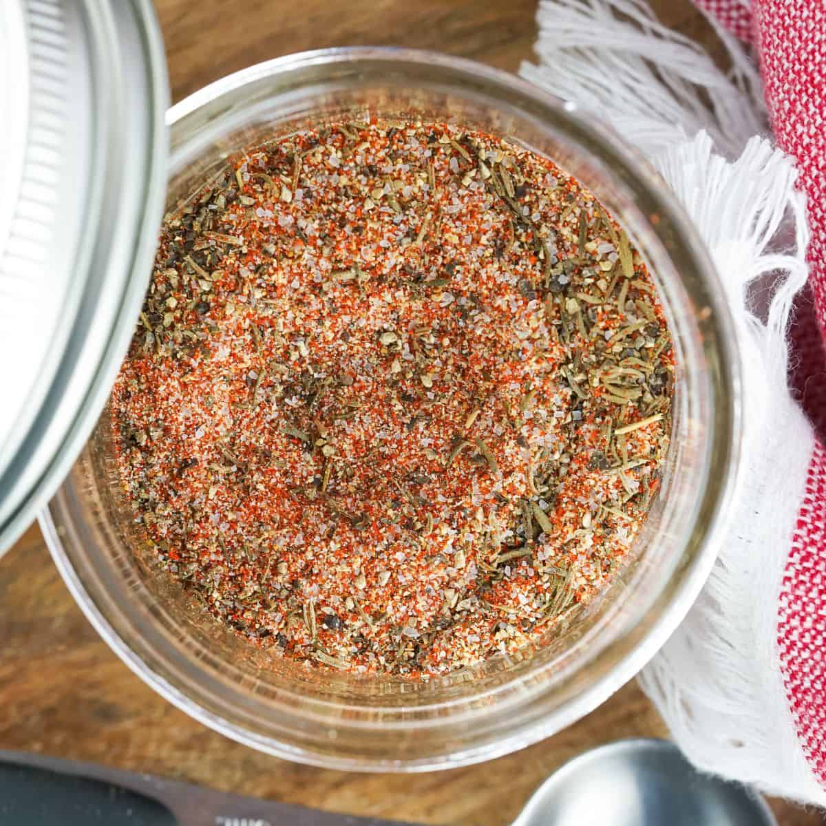 steak seasoning blend in mason jar on top of cutting board.