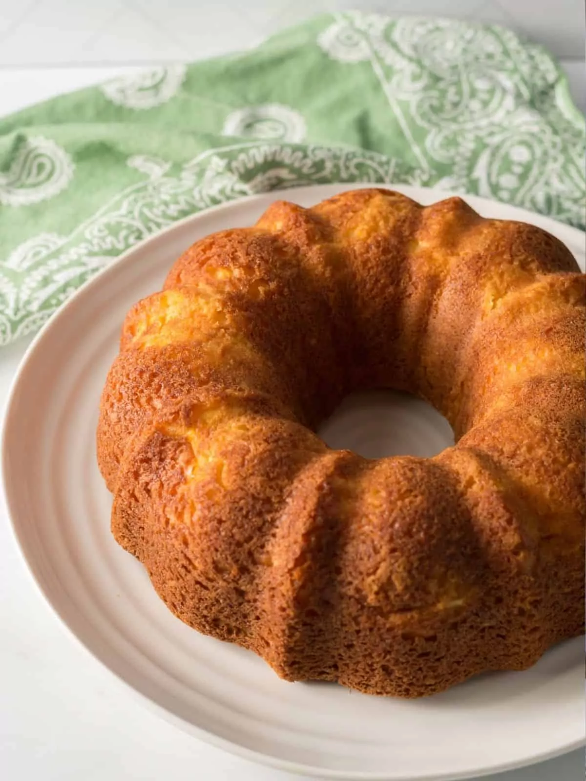 Peach bundt cake with no frosting on white plate.