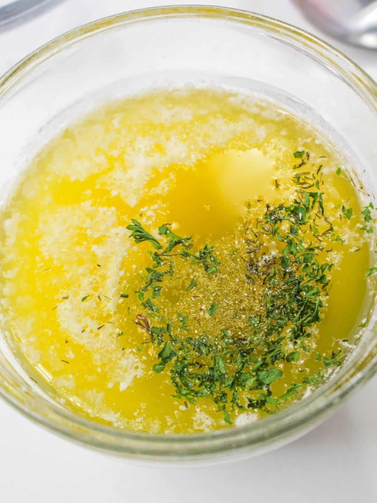 melted butter in glass bowl with spices.
