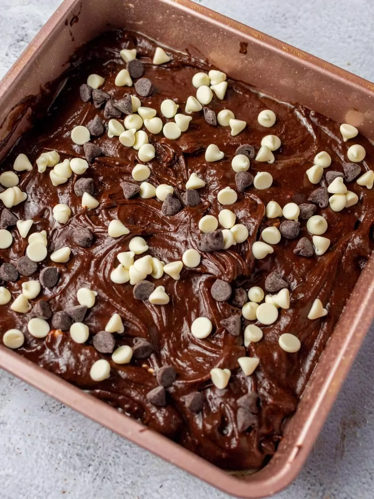 chocolate brownie batter with white and semi-sweet chocolate chips on top.