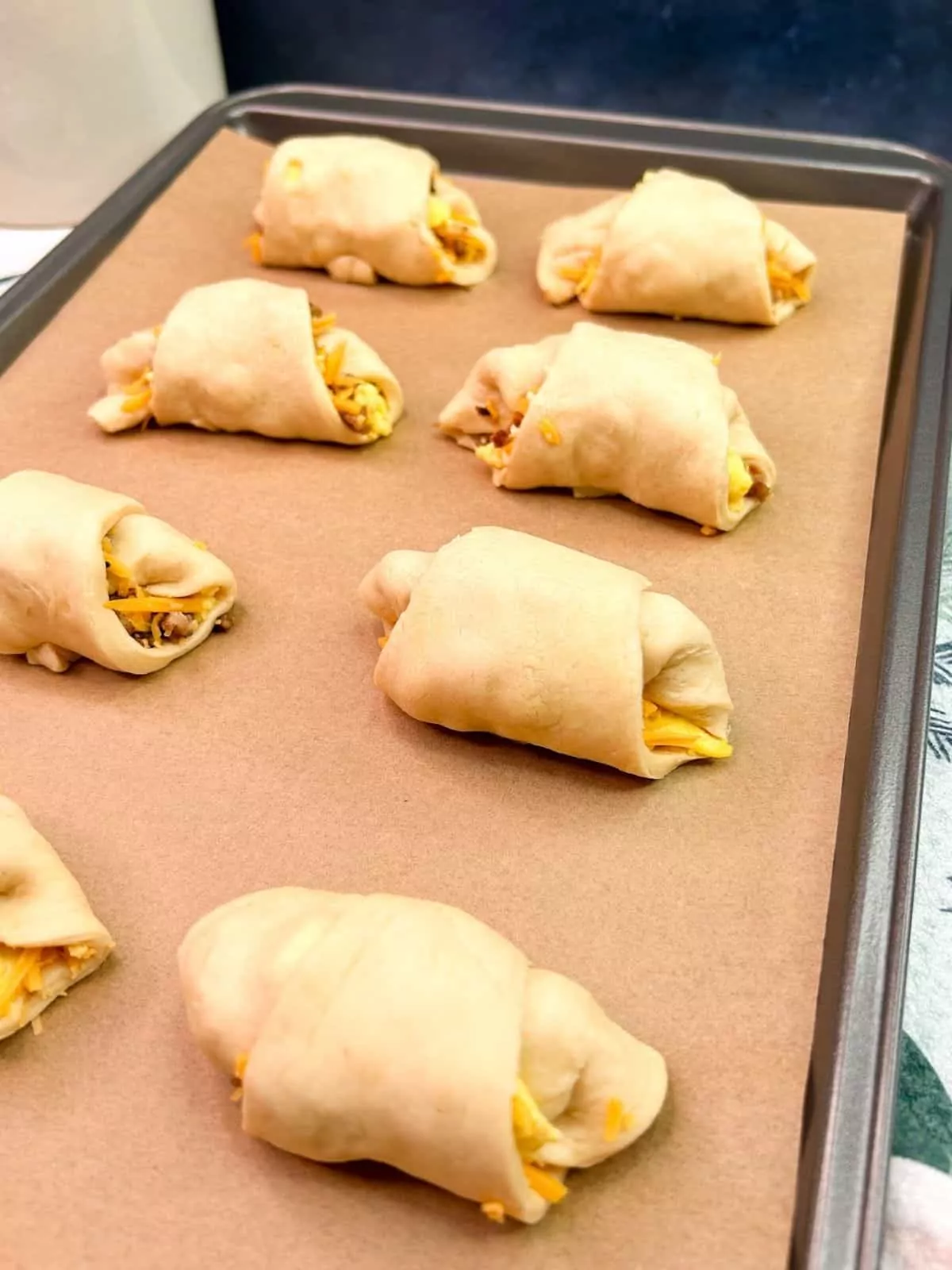 unbaked crescent rolls on baking tray lined with parchment paper.