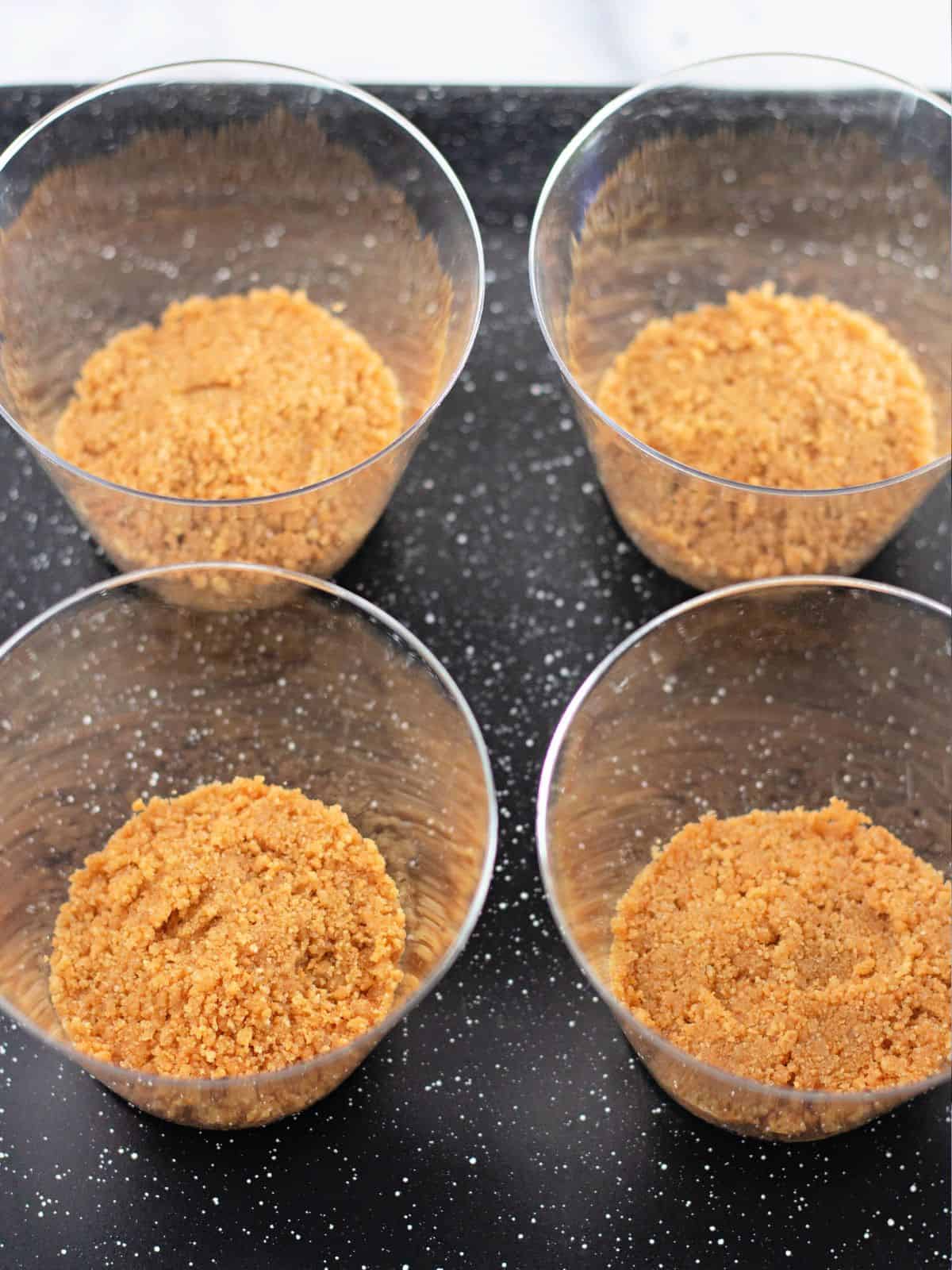 graham cracker crumb mixture in cups.