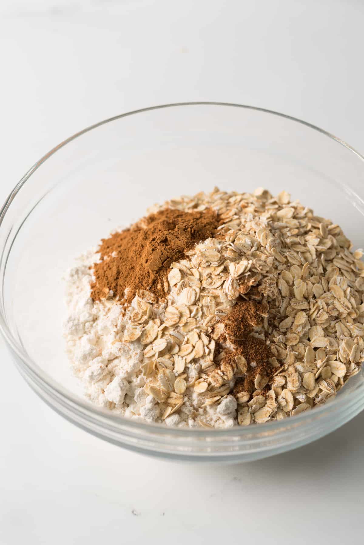 Dry ingredients for oatmeal cookies made with brown sugar substitute in glass bowl.