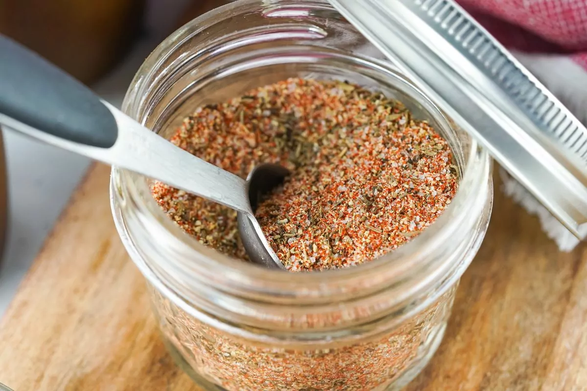 Steak Seasoning in a small mason jar with a measuring spoon