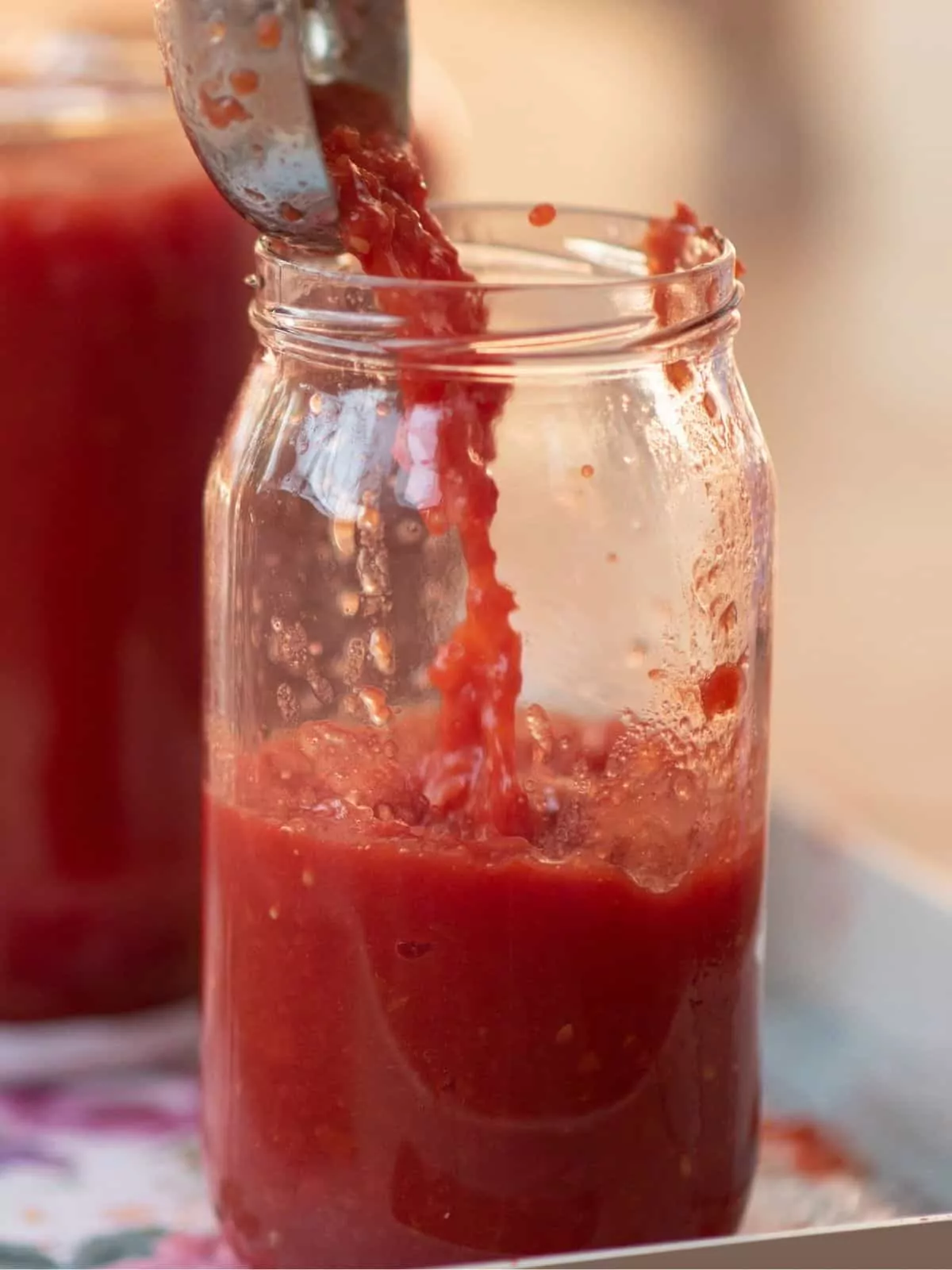 Add cooked tomato sauce in mason jars.