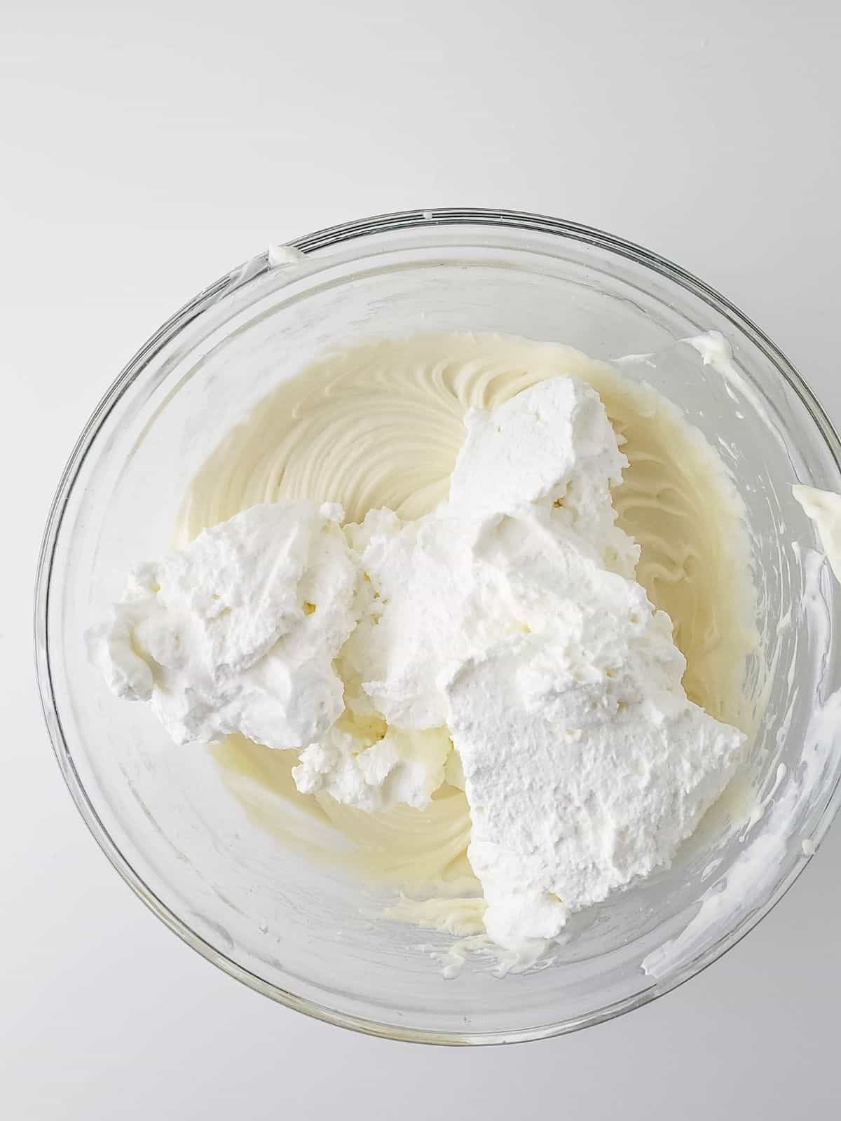 adding whipped cream to cream cheese mixture.