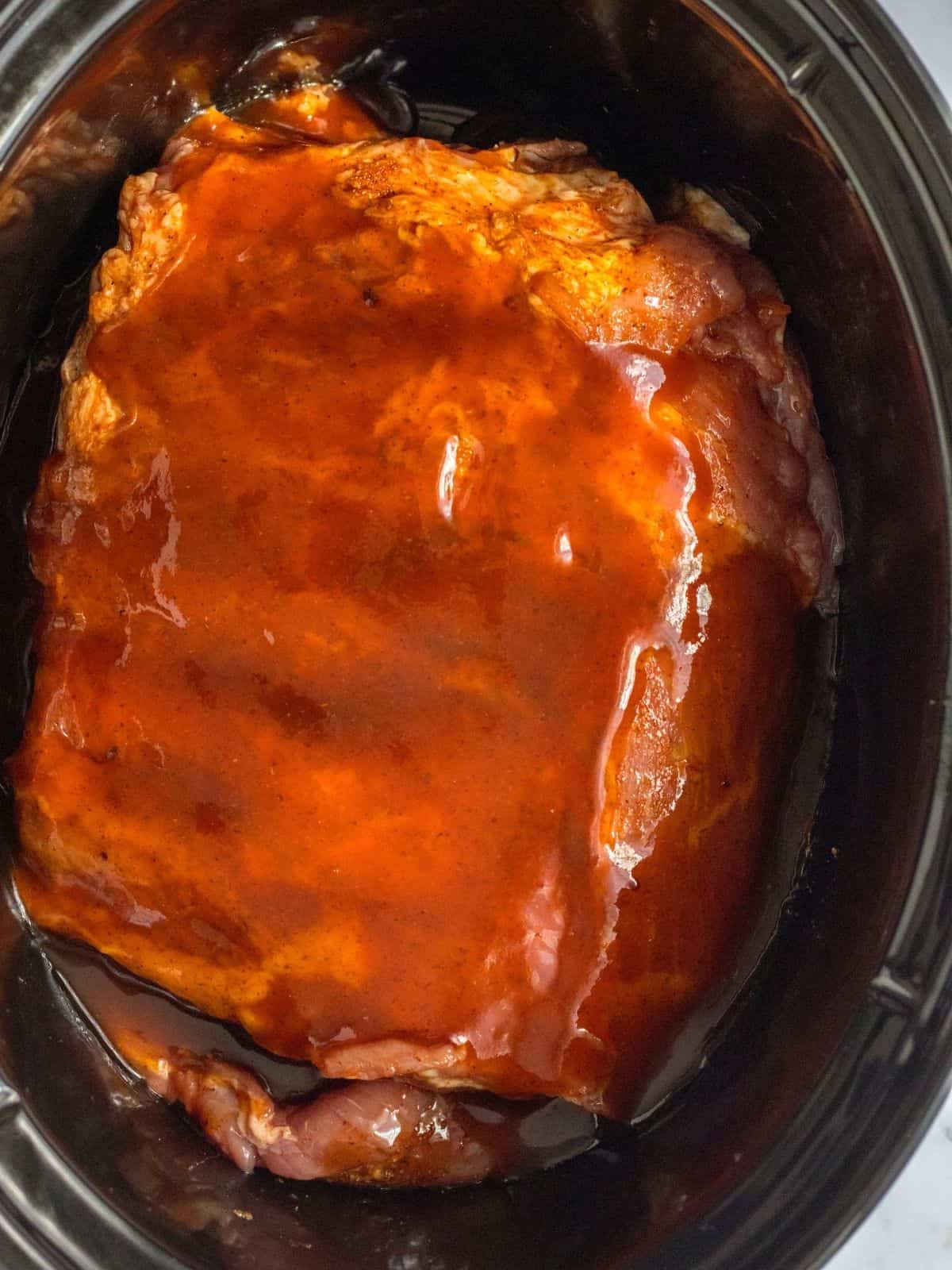 Ribs with barbecue sauce and coke soda in crock pot.