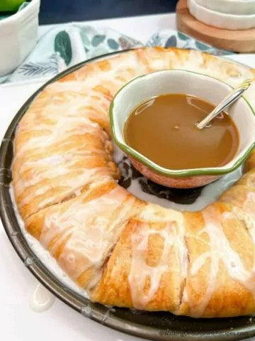 Baked crescent roll apple filling Danish ring with caramel sauce in the center.