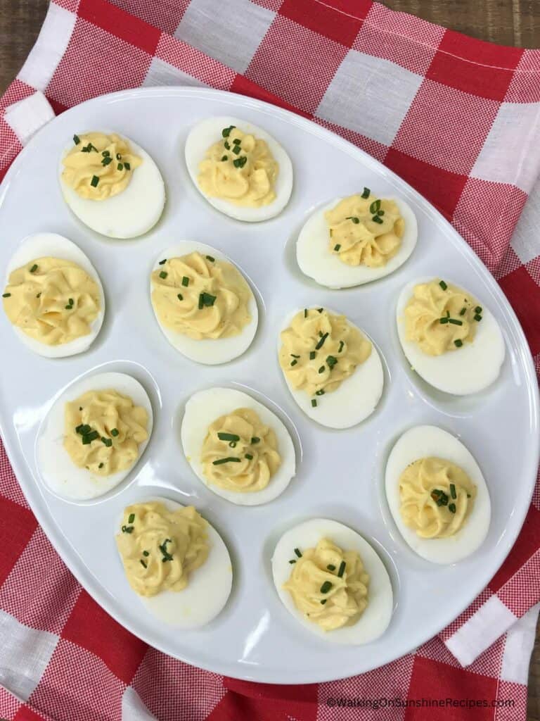 classic deviled eggs in egg plate on gingham napkin.