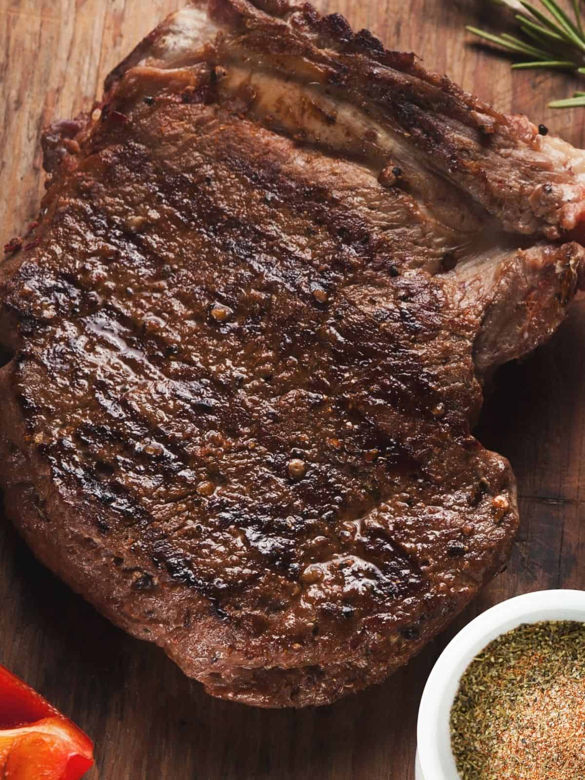 grilled steak with seasonings in small bowl.