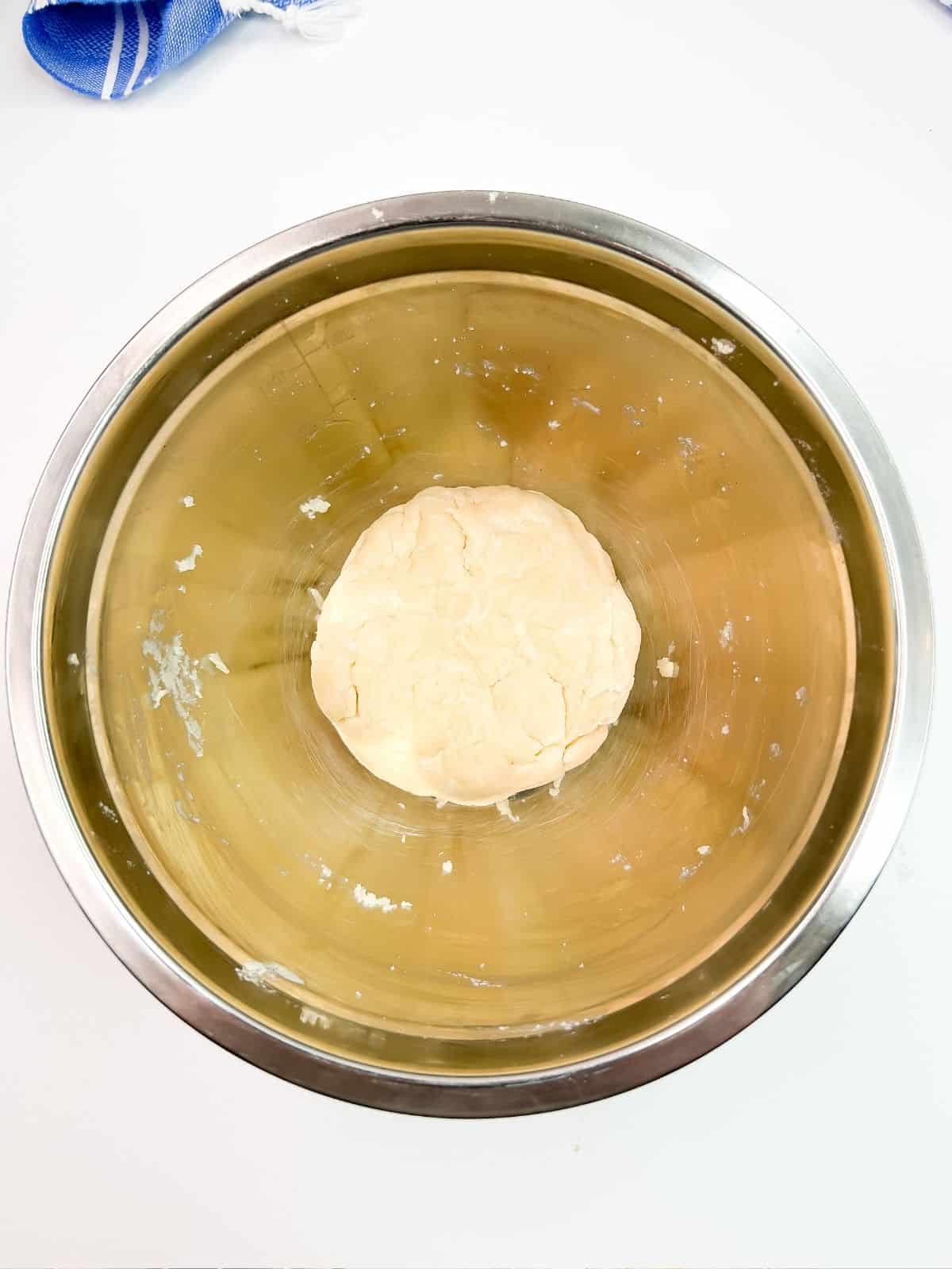 pie dough disc in metal bowl.