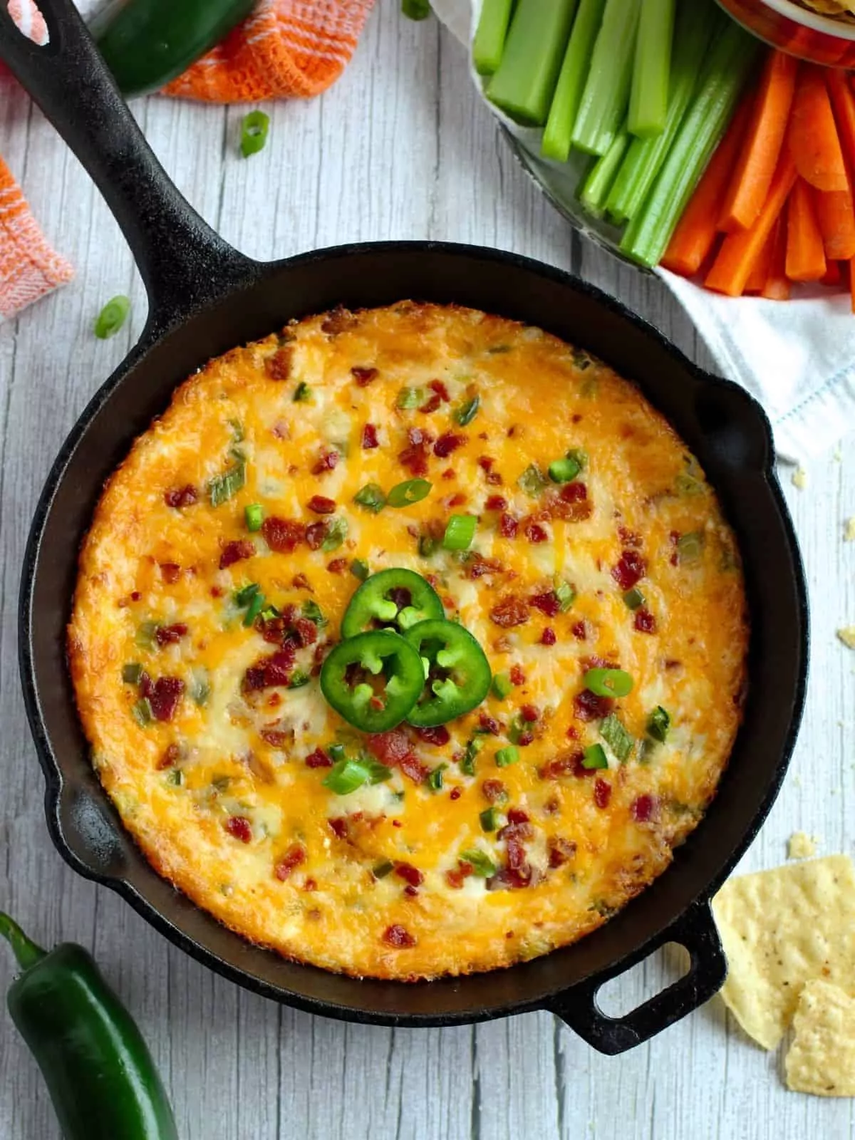 overhead photo of baked jalapeno dip in cast iron skillet.