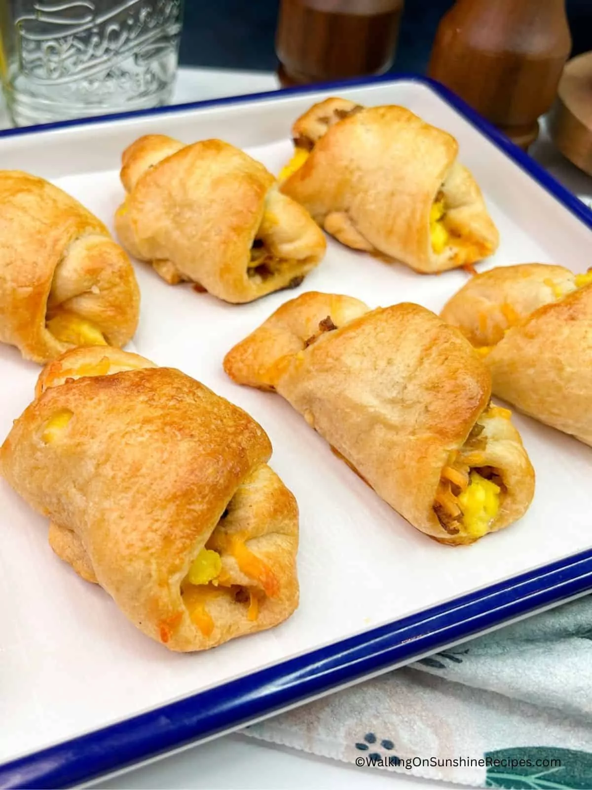 baked breakfast crescent rolls on white tray.