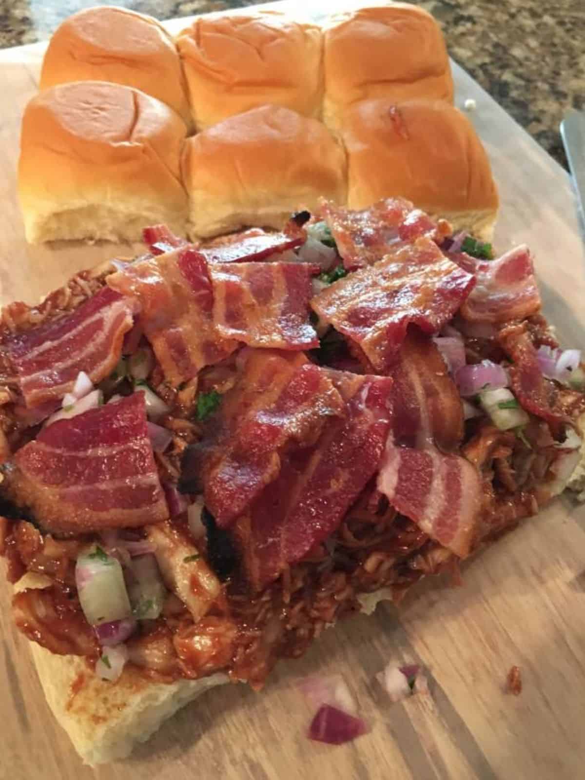 slider sandwich rolls with bbq chicken, onions, cheese and bacon.