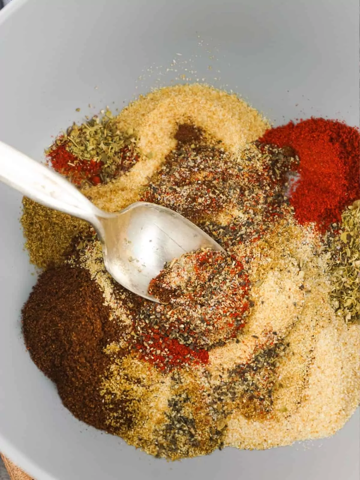taco seasoning mix combined in bowl with spoon.