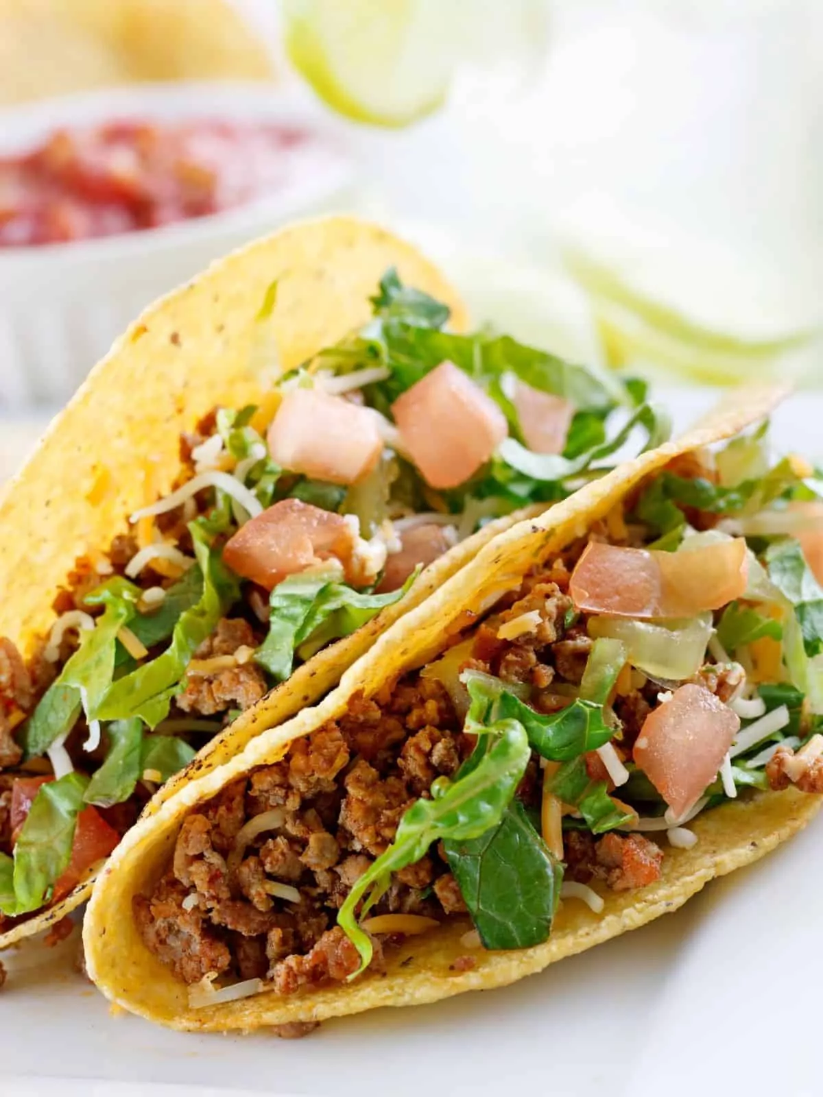 tacos with seasoned beef, lettuce, tomatoes and cheese.
