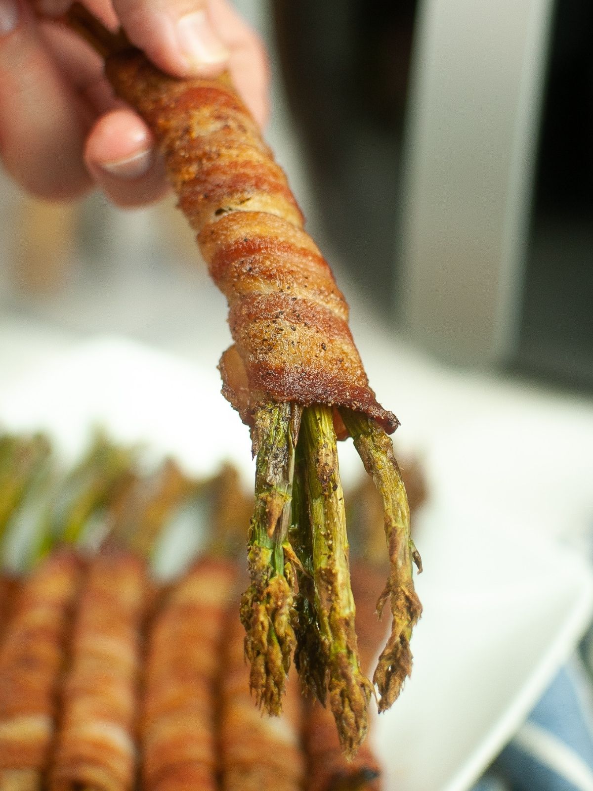 closeup of asparagus bunch wrapped in bacon.