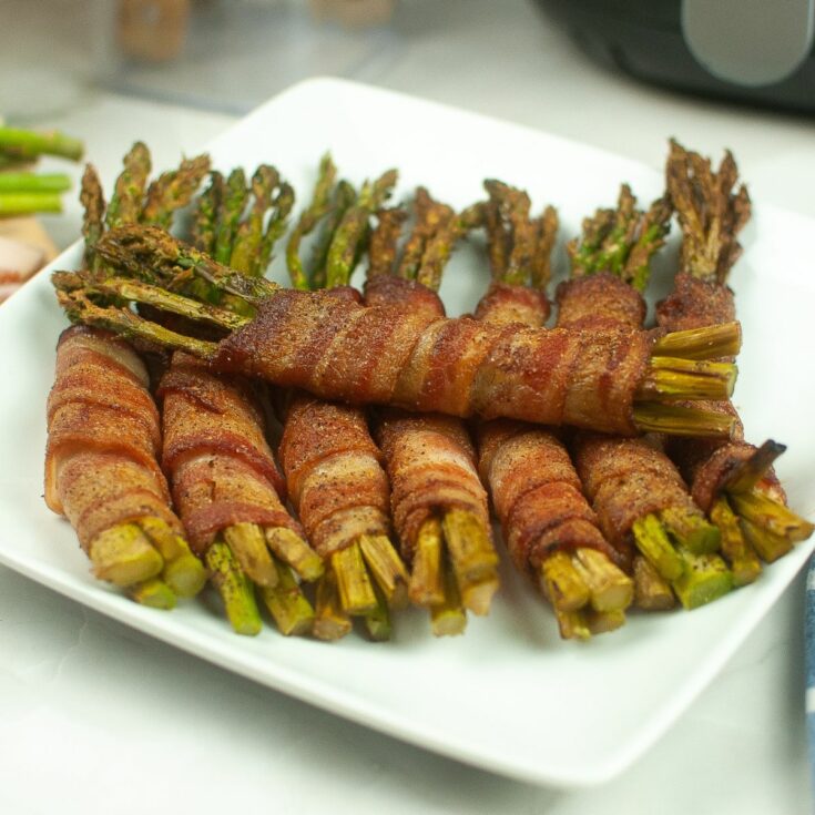 bacon wrapped asparagus on white plate.