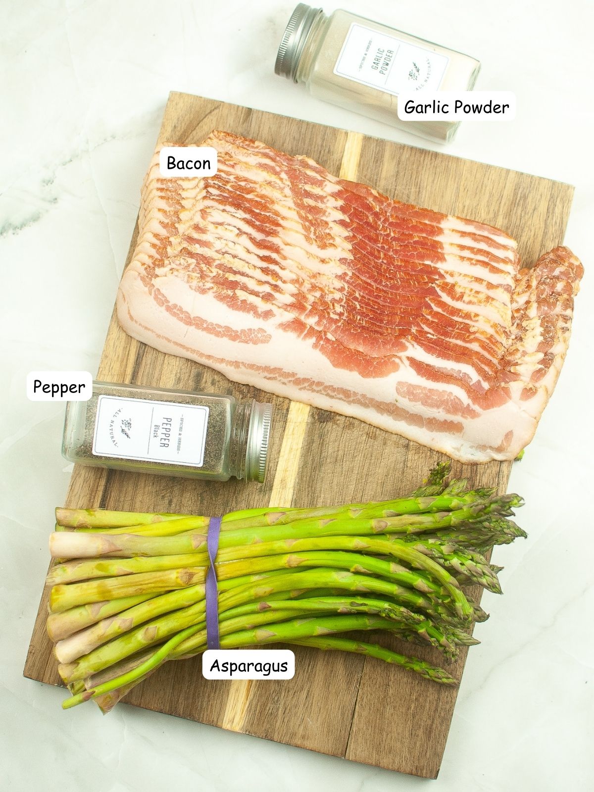 bacon, asparagus, pepper, garlic powder on cutting board.