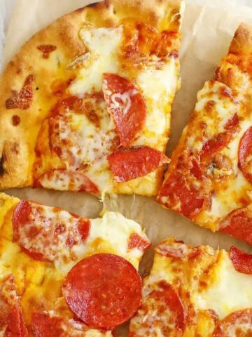 A pepperoni pizza on a wooden board.