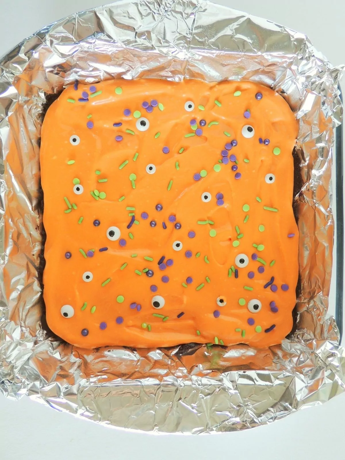 Halloween brownies with orange frosting and googly eyes.