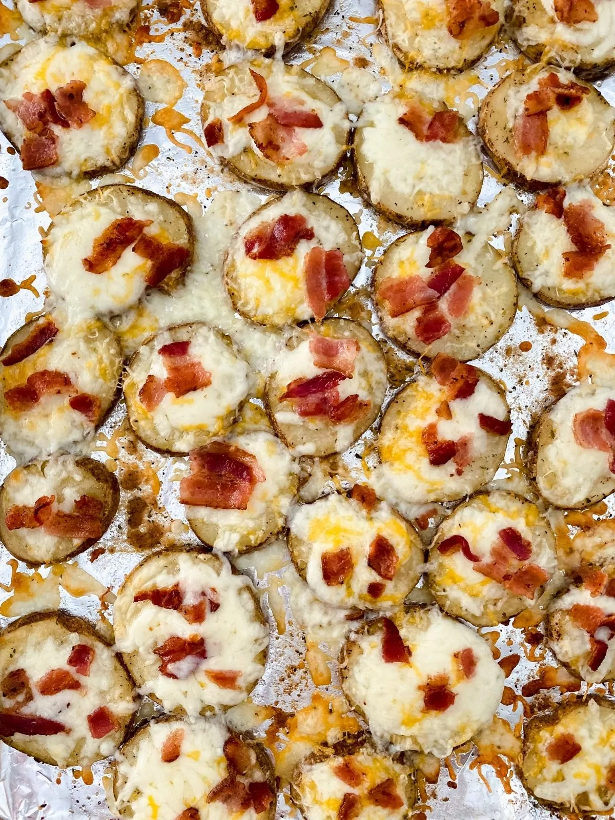 Melted cheese on potato slices with bacon.