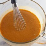 Pumpkin puree mixture combined in bowl with wire whisk.