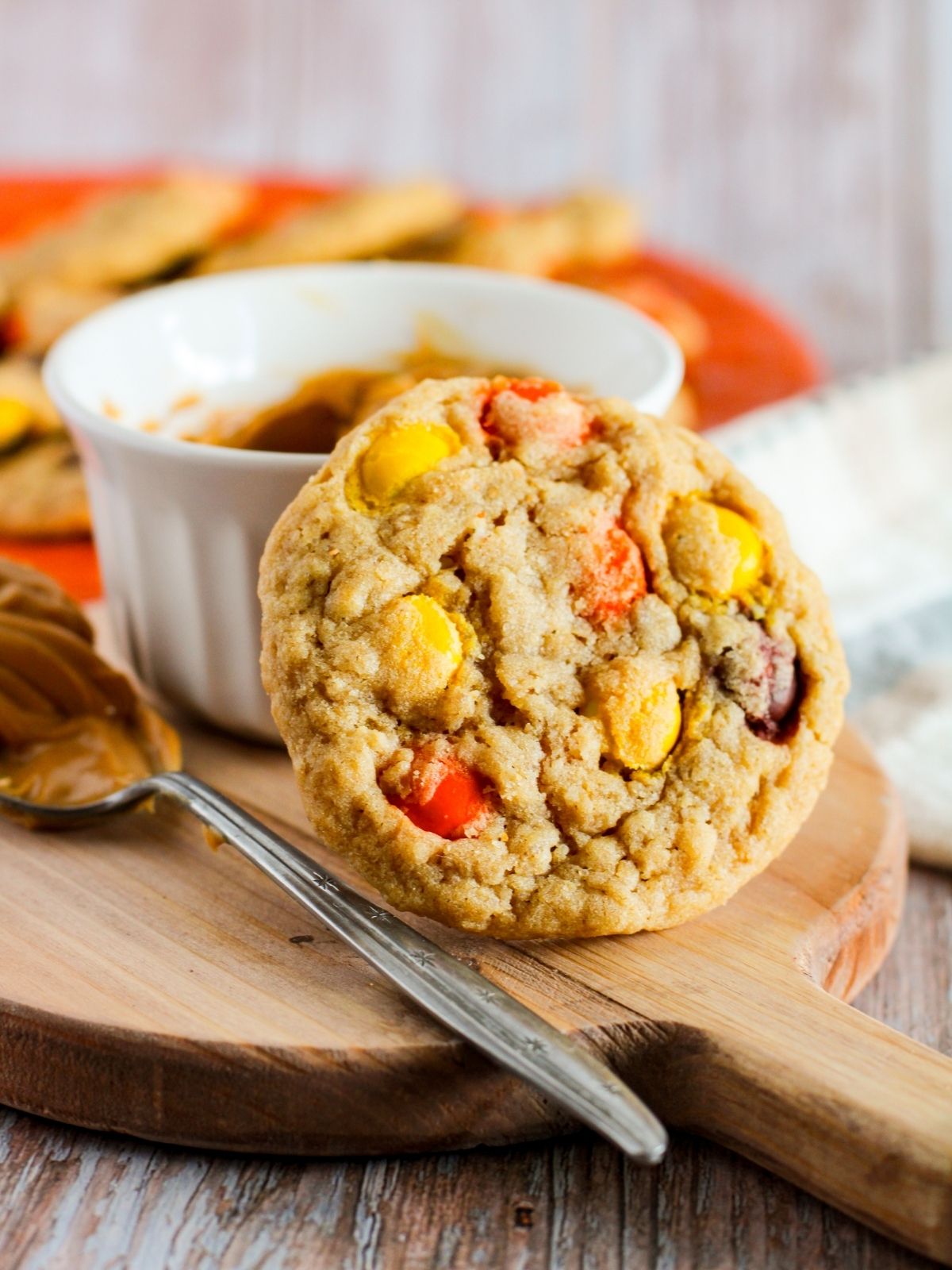 Closeup of Halloween cookies on board with spoon of peanut butter.