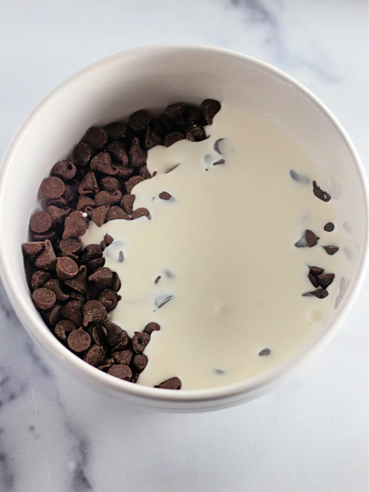 chocolate chips mixed with heavy cream in bowl.