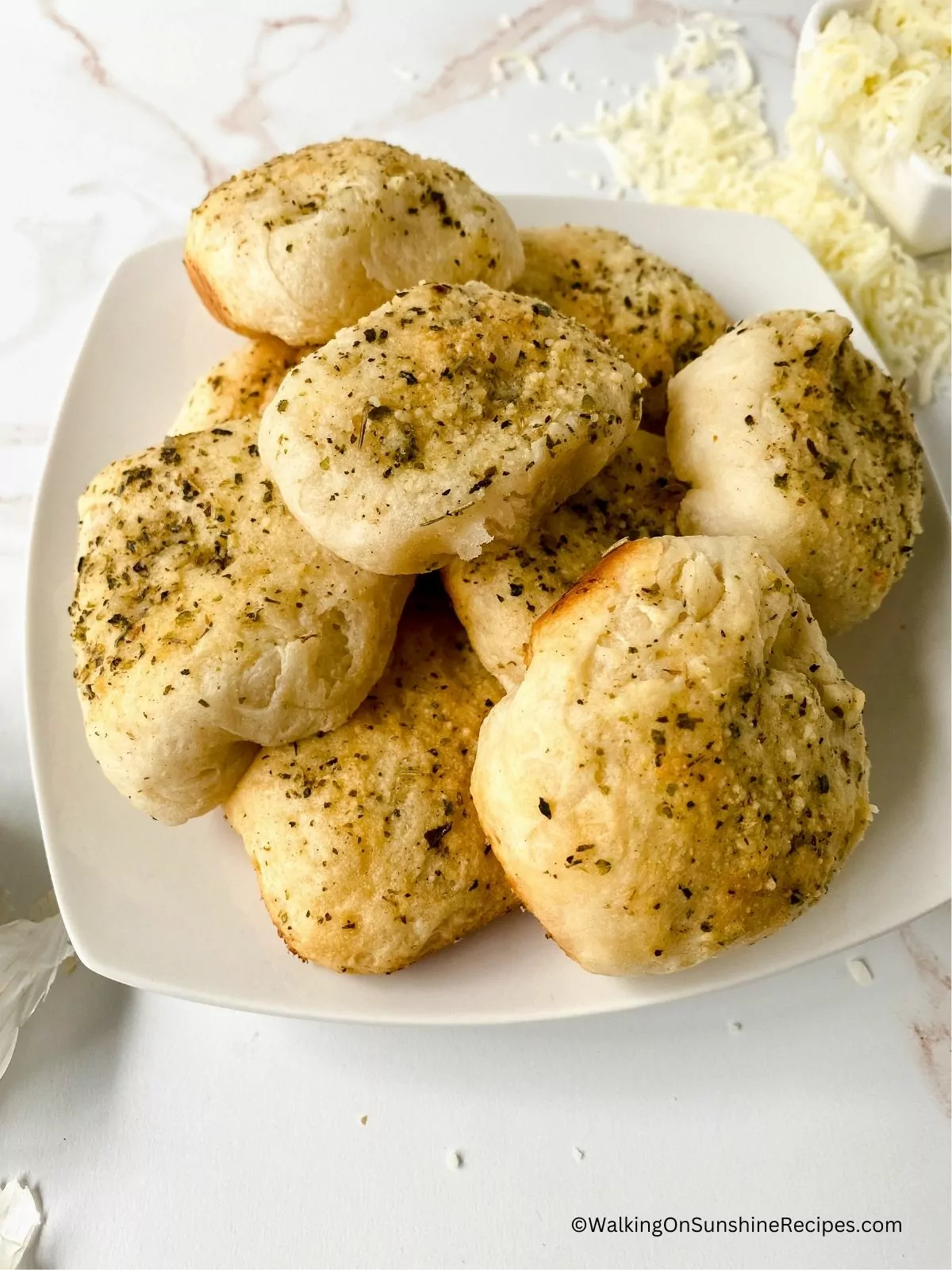 Refrigerator biscuits baked with mozzarella cheese on white plate.