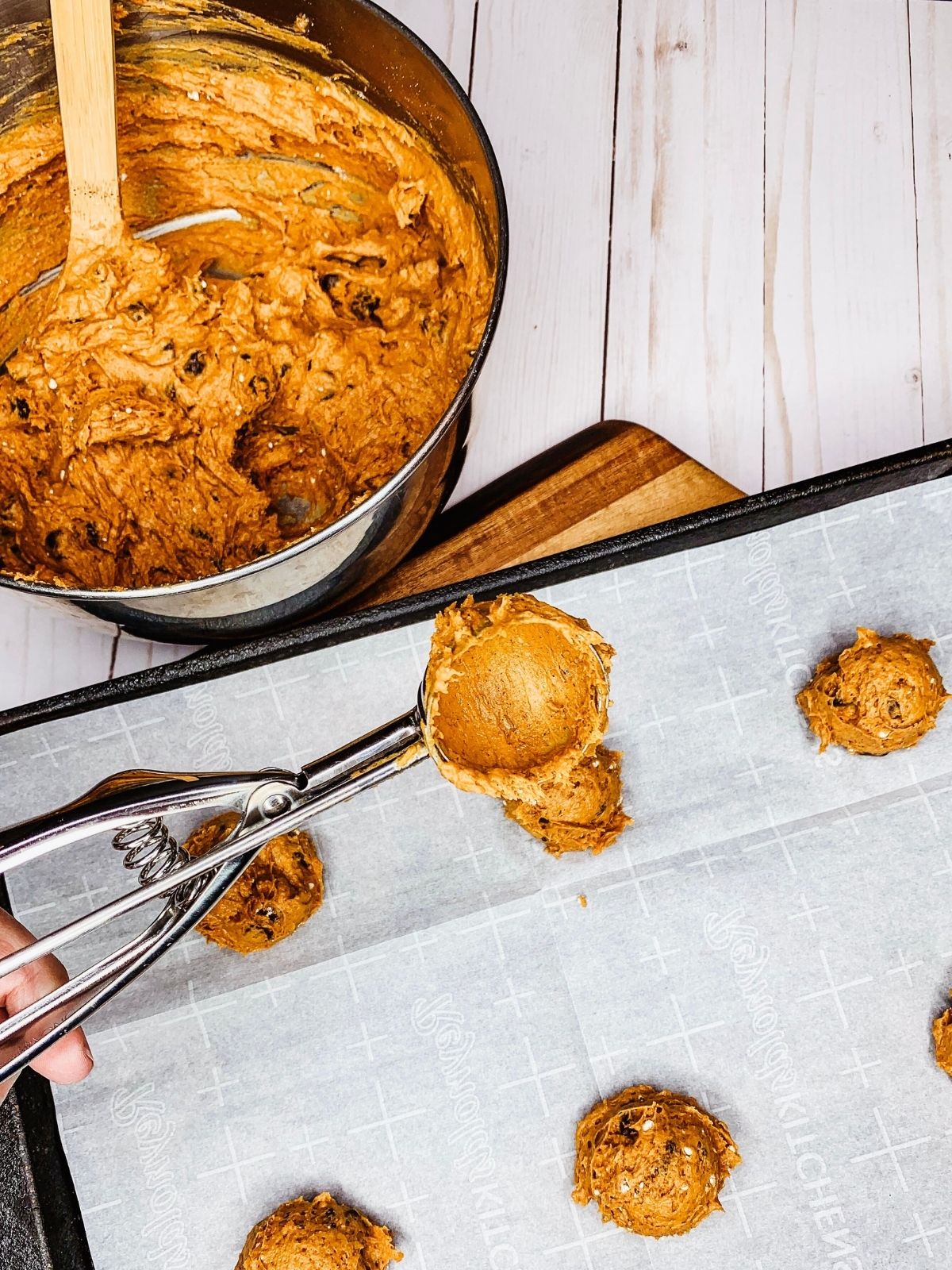small cookie scoop with cookie dough on baking rack.