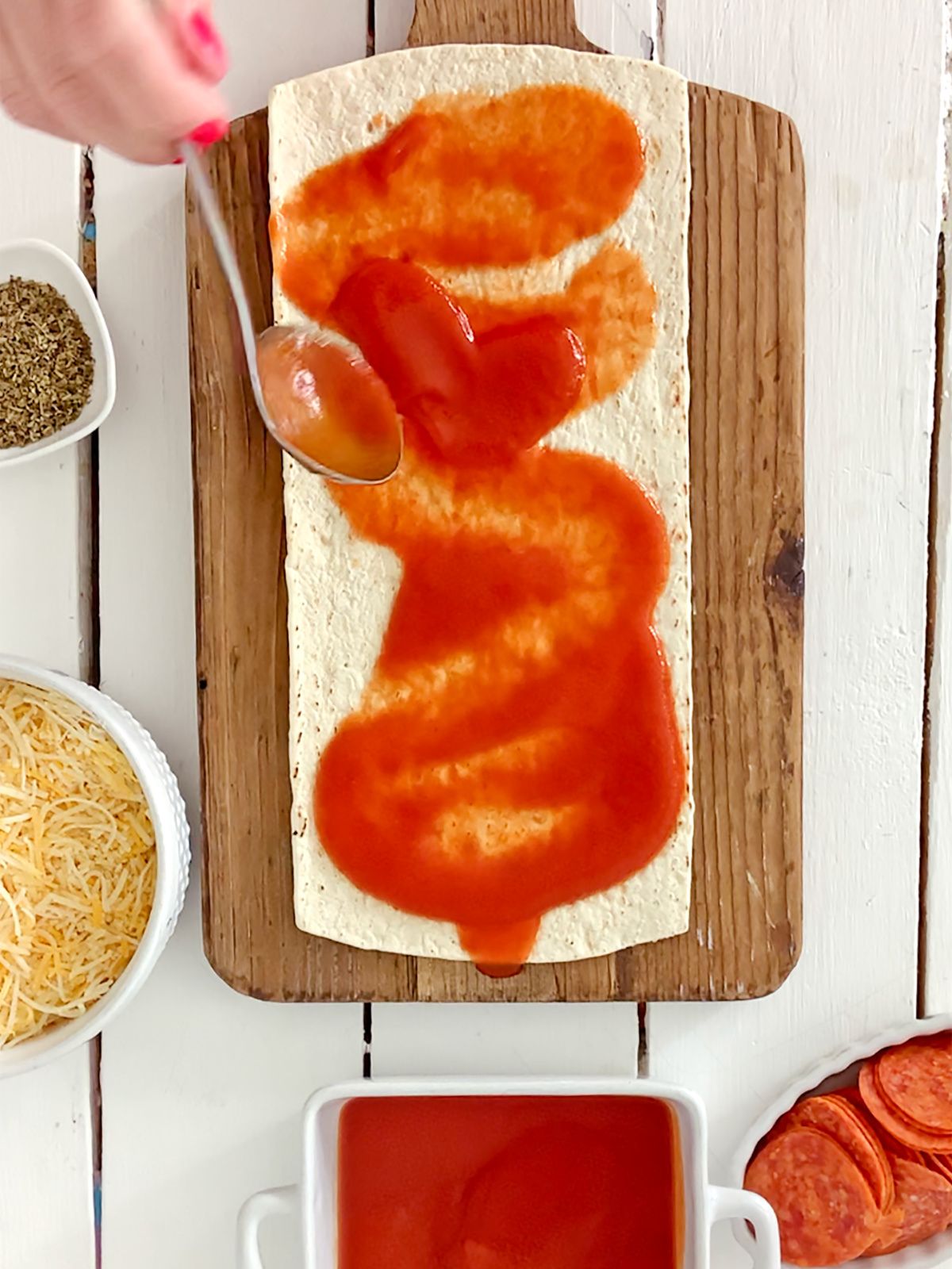 marinara sauce spread on top of naan flatbread for pizza.